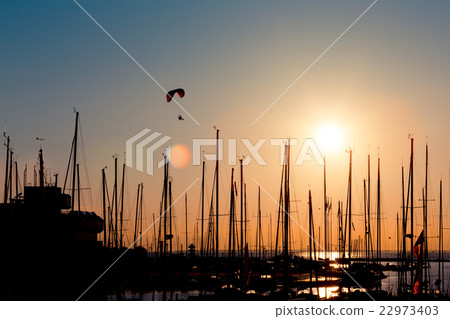 Sunset paragliding over yachts 22973403