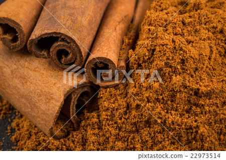 cinnamon sticks with powder on dark stone plate cinnamon sticks with powder on dark stone plate 22973514