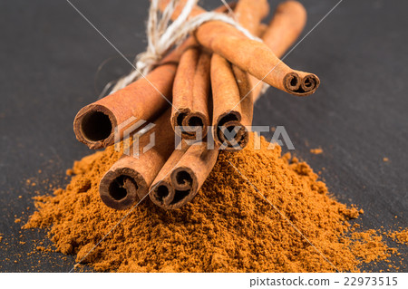 cinnamon sticks with powder on dark stone plate cinnamon sticks with powder on dark stone plate 22973515
