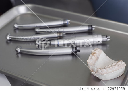 Human gypsum jaw and dental handpieces on tray 22973659