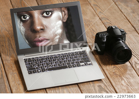 Dark-skinned woman portrait on laptop screen 22973663
