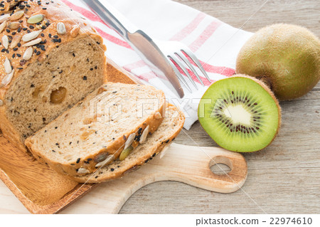 Kiwi fruit and whole wheat bread on wooden table. Kiwi fruit and whole wheat bread on wooden table. 22974610