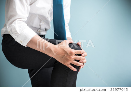 A businessman holding a knee 22977045