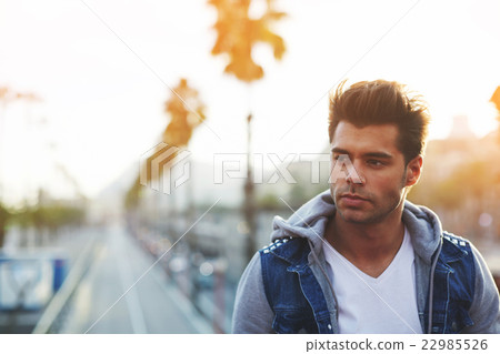Attractive male posing for camera on the street  22985526