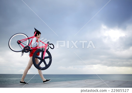 Hipster girl stroll with bicycle at seashore Hipster girl stroll with bicycle at seashore 22985527