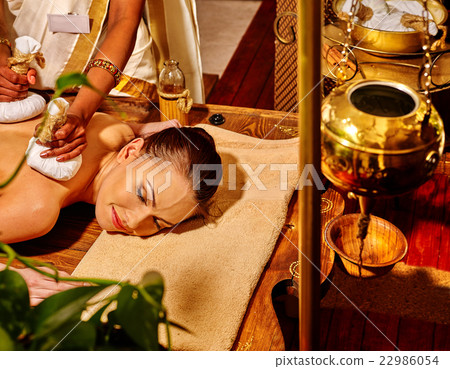 Woman having massage with pouch of rice. Woman having massage with pouch of rice. 22986054