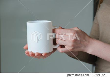 White cup in hand of a girl White cup in hand of a girl 22991840