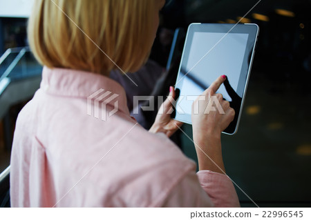 Young successfulwoman browsing on pad Young successfulwoman browsing on pad 22996545