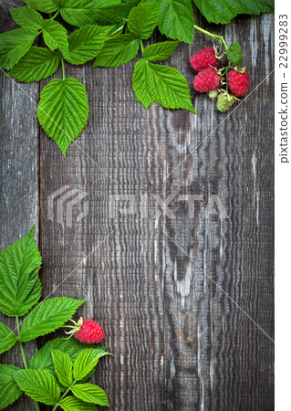 Old wooden board decorated raspberry and leaves Old wooden board decorated raspberry and leaves 22999283