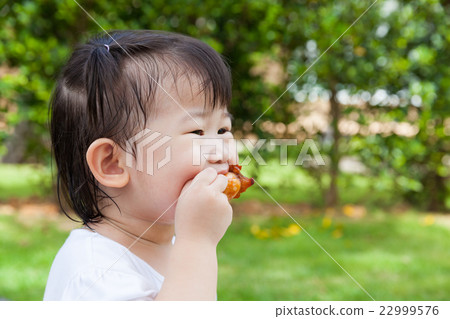 Closeup little asian girl enjoy eating her lunch 22999576