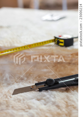 Measure tape and knife on mineral wool Measure tape and knife on mineral wool 23000214