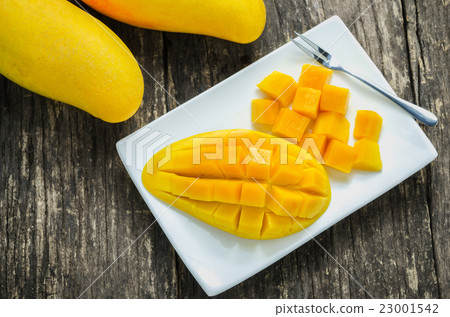 Slice of golden mangoes at white dish 23001542