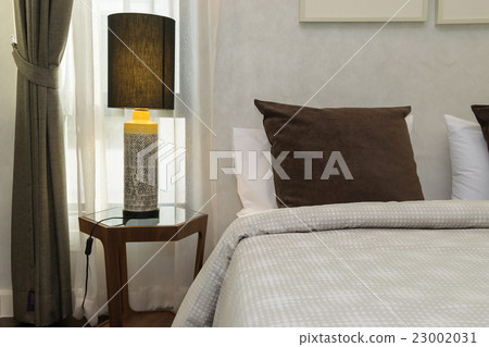 brown pillows on bed with lamp 23002031