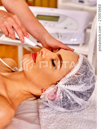Woman receiving electric facial peeling massage. 23003668
