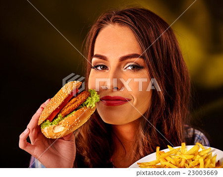 Happy girl holding fastfood hamburger and fried 23003669
