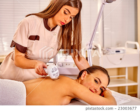 Young woman receiving electric back massage. Young woman receiving electric back massage. 23003677