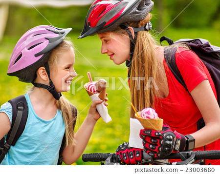 Bicycle girls cycling eating ice cream cone in 23003680