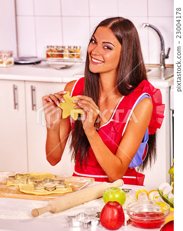 Young woman baking cookies in oven. 23004178