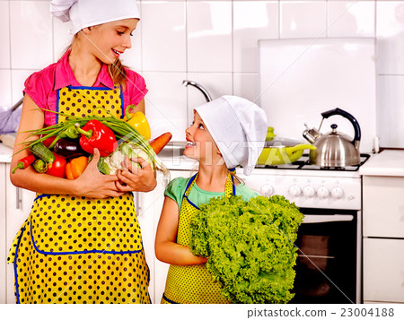 Children little girl cooking vegetables at kitchen Children little girl cooking vegetables at kitchen 23004188