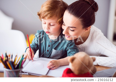 Mother looking at child drawing a picture 23010212