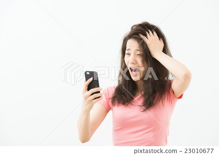 A woman watching a mobile phone A woman watching a mobile phone 23010677