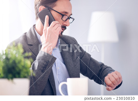 Man looking at watch while having conversation Man looking at watch while having conversation 23010810