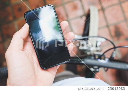 image of a biker texting on a smart phone 23012983