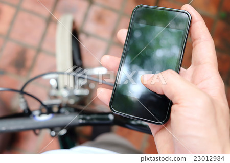 image of a biker texting on a smart phone 23012984