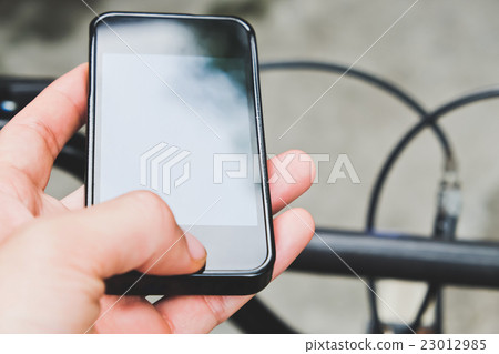 image of a biker texting on a smart phone 23012985