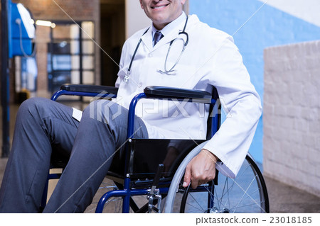 Male doctor sitting on wheel chair 23018185
