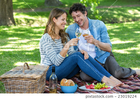 Couple having a picnic with wine 23019224