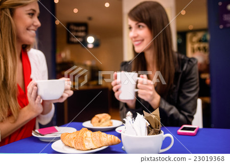 Women having coffee and snacks at a coffee shop 23019368
