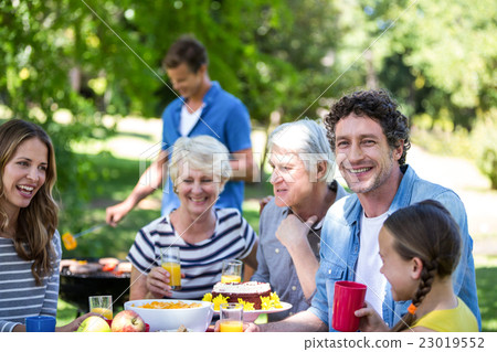 Family and friends having a picnic with barbecue Family and friends having a picnic with barbecue 23019552