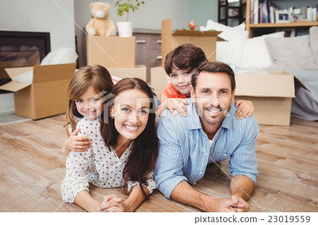 Portrait of happy family lying on hardwood floor Portrait of happy family lying on hardwood floor 23019559