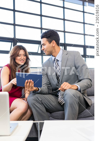 Businessman and businesswoman using digital tablet 23019816