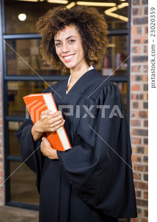 Lawyer standing near library with law book Lawyer standing near library with law book 23020359