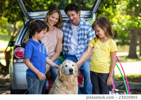 Smiling family in front of a car Smiling family in front of a car 23020905
