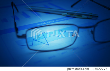 Glasses and pen on blue financial chart and graph 23022773
