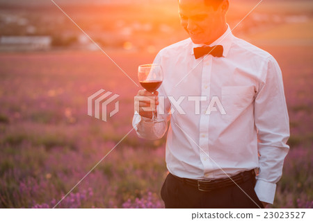 Elegant young guy drinking wine on sunset Elegant young guy drinking wine on sunset 23023527