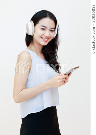 Young pretty lady with tablet and headphones isolated on white 23026852