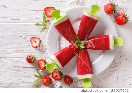 Strawberry ice cream with mint on a stick closeup Strawberry ice cream with mint on a stick closeup 23027962