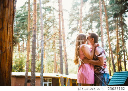 Romantic young couple kissing on background forest Romantic young couple kissing on background forest 23028162