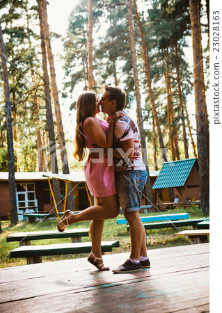 Romantic young couple kissing on background forest Romantic young couple kissing on background forest 23028163