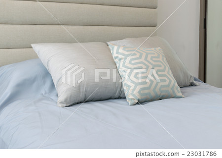 Comfortable soft pillows on the light blue bed 23031786