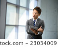 3 30-year businessman standing at the window of an inorganic office 23034009