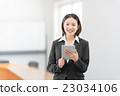 A woman in her twenties standing with a tablet in the office car 23034106