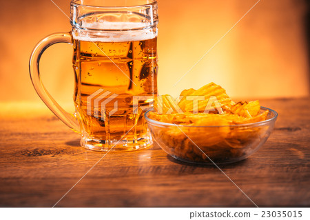 beer mug with a bowl of potato chips on table beer mug with a bowl of potato chips on table 23035015