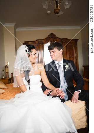 beautiful young couple sitting on the bed beautiful young couple sitting on the bed 23036723