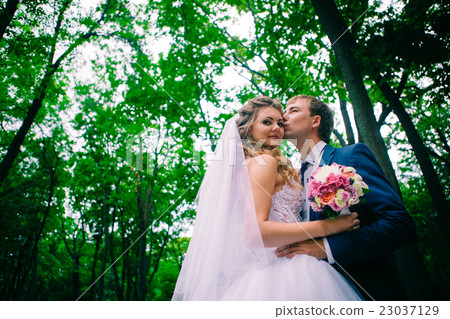 young couple posing in park on background trees young couple posing in park on background trees 23037129
