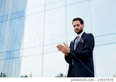 Man with good feeling standing near office Man with good feeling standing near office 23037978